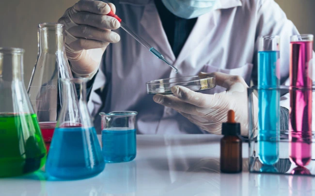 Scientist handling chemical samples with laboratory glassware and storage containers for safe chemical storage solutions